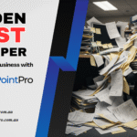 Office desk piled with paper folders and documents — hidden cost of paper