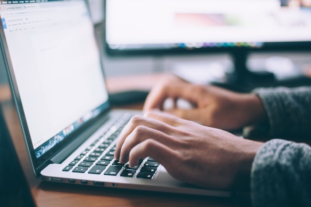 IT administrator typing on a laptop while running a PowerShell script to force Azure AD Connect sync.