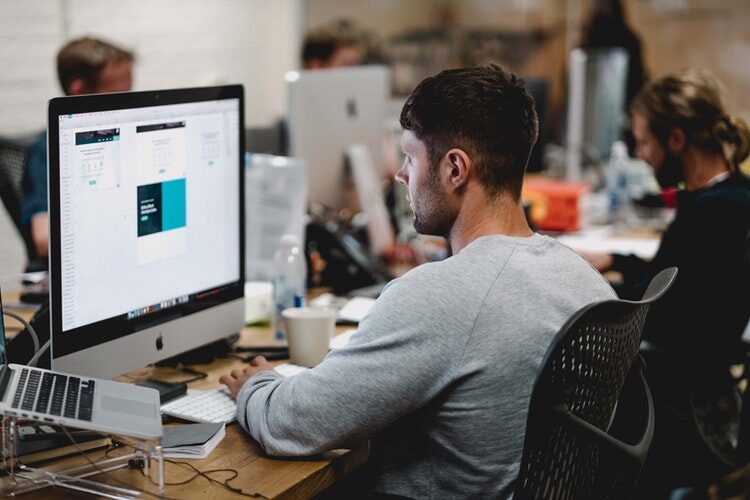 Developer working at a desk reviewing SharePoint bulk delete script on a computer